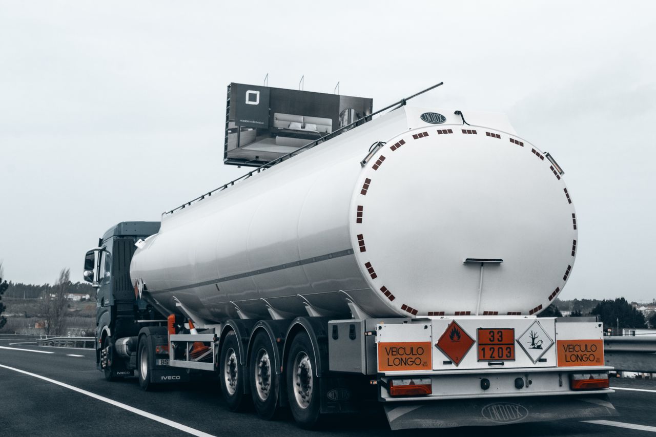 Rear view of a large tanker truck transporting fuel on a highway, emphasizing logistics and transportation.