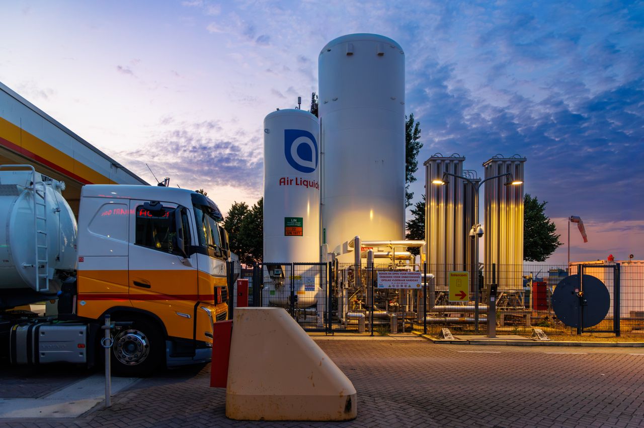 A vibrant sunset over a fueling station with tanks and trucks in Rotterdam, Netherlands.